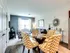 Bright and inviting living space with stylish chevron-patterned chairs around a glass dining table, cozy seating area, and chic decor at Union Flats..