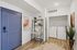Chic apartment entryway featuring modern artwork, stylish shelving, and convenient in-unit laundry at Emerson Flats.