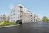 Modern apartment complex exterior with spacious balconies, ample parking, and a sleek, contemporary design at Emerson Flats..