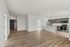 Spacious open-concept apartment with sleek kitchen, modern appliances, and elegant wood flooring at Emerson Flats.