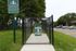 Inviting dog park entrance with lush greenery, perfect for pet-friendly apartment living and community enjoyment at Perkins Place.