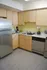 Modern kitchen equipped with a refrigerator and stove, located in Perkins Place Apartments.