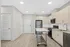 Modern kitchen with sleek light wood cabinetry, high-end stainless steel appliances, and a spacious island cart on elegant wood flooring at Yard 56 Lofts.