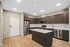 Modern kitchen with sleek dark wood cabinets, stainless steel appliances, and spacious island, perfect for culinary enthusiasts at Yard 56 Lofts.