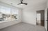 Bright and airy bedroom with large windows, modern ceiling fan, and plush carpet, offering serene views and abundant natural light at Emerson Flats.