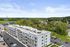 Charming apartment building surrounded by lush greenery and open skies, offering a serene escape with convenient parking at Emerson Flats.