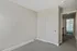 Inviting room with soft gray walls and plush carpeting leading to a bright bathroom featuring modern fixtures and natural light.