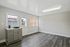 Bright room with natural light, sleek gray cabinetry, and stylish wood flooring, offering a modern, open feel.