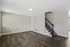 Modern living area with elegant hardwood floors and sleek staircase, perfect for a cozy and inviting home atmosphere.