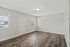 Bright and inviting living area with sleek hardwood flooring, fresh neutral walls, and ample natural light from large windows.