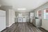 Bright and modern kitchen with sleek gray cabinets, stainless steel appliances, and wood-style flooring.