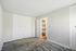 Bright, spacious bedroom with plush carpeting, built-in storage, and a modern en-suite bathroom.