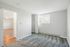 Bright and inviting bedroom with plush carpeting, enhanced by natural light from a wide window, offering a cozy atmosphere.