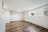 Bright living area with large window, elegant wood flooring, and modern lighting.