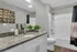 Elegant bathroom with granite countertop, modern fixtures, decorative wall art, and a vibrant plant for a touch of nature.