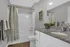Elegant bathroom with modern fixtures, granite countertop, and stylish gray and white decor.