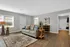 Inviting living room with chic decor, plush sofa, elegant wooden flooring, and abundant natural light, seamlessly connected to a modern bathroom.