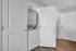 Modern apartment with a discreet in-unit washer and dryer tucked behind sleek white doors, featuring stylish hardwood flooring.