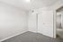 Bright bedroom with plush gray carpet and ample closet space, exuding warmth and comfort with a modern touch.