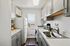 Modern kitchen with sleek gray cabinets, stainless steel sink, and a window view offering cityscape scenery.