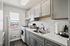 Charming kitchen with sleek gray cabinets, modern appliances, and a bright window view.