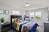 Bright and modern bedroom featuring a stylish bed with colorful pillows, natural light from large windows, and chic décor for a cozy atmosphere.