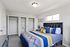 Bright and inviting bedroom featuring a plush bed with colorful bedding, ample closet space, and modern decor.