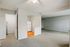 Inviting interior showcasing an open-concept living space with cozy carpeted flooring, a compact kitchen area, and abundant natural light.