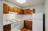 Cozy kitchen with modern white appliances, rich wooden cabinets, and elegant countertops.