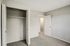 Bright and spacious bedroom with a modern open closet and plush carpet flooring, perfect for a welcoming personal retreat.