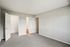 Bright and spacious bedroom with plush carpeting, featuring an ensuite bathroom and ample closet space for modern living.