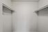 Spacious walk-in closet with ample shelving in modern apartment.