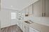 Elegant kitchen featuring modern gray cabinets, stainless steel appliances, and sleek wood flooring.