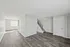Bright, open-concept living space with modern laminate flooring and staircase, perfect for a stylish and airy ambience.