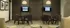 Elegant community meeting room with modern decor, cozy chairs, wall-mounted screens, and ambient lighting.