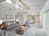 Spacious and bright living area with vaulted ceilings, cozy gray sofas, and a modern dining space, perfect for relaxation and entertaining.