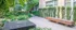 Charming courtyard in a modern apartment complex with lush greenery, a sleek water feature, and inviting seating area.