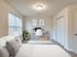 Modern and bright bedroom with elegant workspace featuring a cozy bed, stylish decor, and ample natural light.
