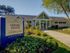 Inviting leasing center with a modern fitness facility, surrounded by lush landscaping and vibrant floral gardens.