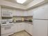 Charming kitchen with modern white cabinetry, sleek countertop, and essential appliances, perfect for culinary creativity.