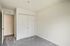 Bright Bilotta bedroom with fresh carpet, smooth walls, and a spacious closet with white sliding doors.