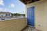 Inviting balcony at the Reserve at Sawmill with blue door, overlooking vibrant community, greenery, and ample parking.