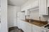Charming kitchen with sleek white cabinetry, elegant brown countertops, and modern appliances, perfect for culinary creativity.