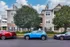 Charming apartment complex with modern architecture, lush greenery, and convenient street parking.