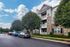 Charming apartment complex with modern architecture and lush green surroundings, offering ample parking and serene living.