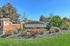 Inviting entrance to Castleton, showcasing vibrant landscaping and elegant brickwork in a serene community setting.