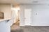 Bright and inviting hallway with modern finishes, plush carpet, and sleek white doors, ideal for a contemporary apartment lifestyle.