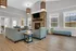 Inviting living room with cozy seating, elegant stone fireplace, and abundant natural light from large windows.
