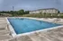 Inviting outdoor swimming pool with lounge chairs and scenic views, perfect for relaxation in a vibrant apartment community.