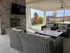 Charming outdoor patio with elegant wicker furniture, stone fireplace, and scenic autumn views.